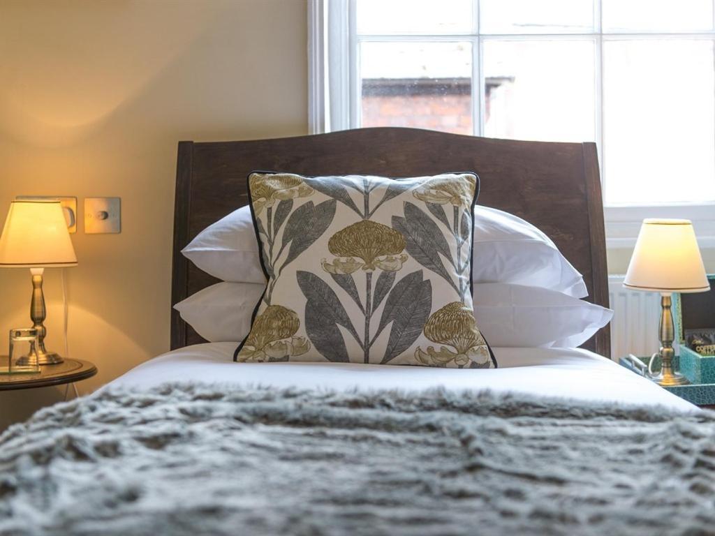Darwin'S Townhouse Panzió Shrewsbury Szoba fotó A bed with a throw